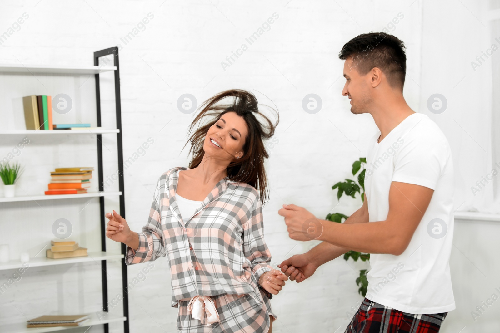 Photo of Happy young couple dancing together at home