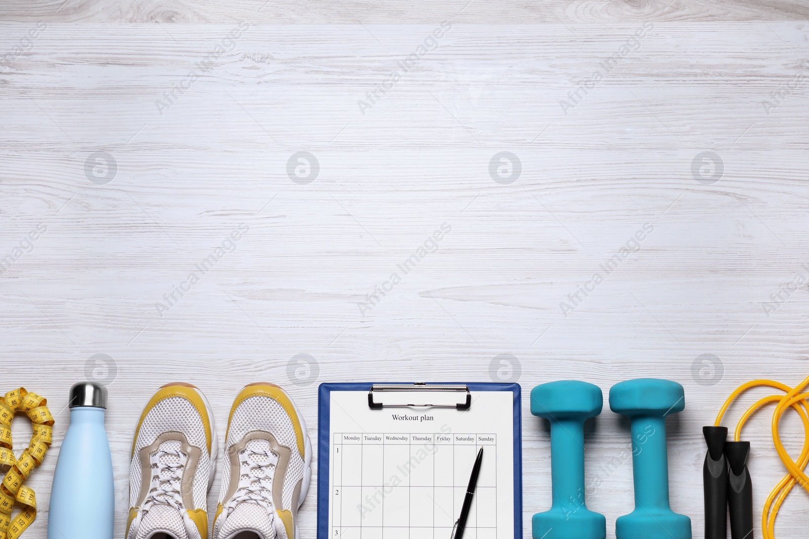 Photo of Personal training. Clipboard with workout plan, sneakers and sports equipment on white wooden table, flat lay. Space for text