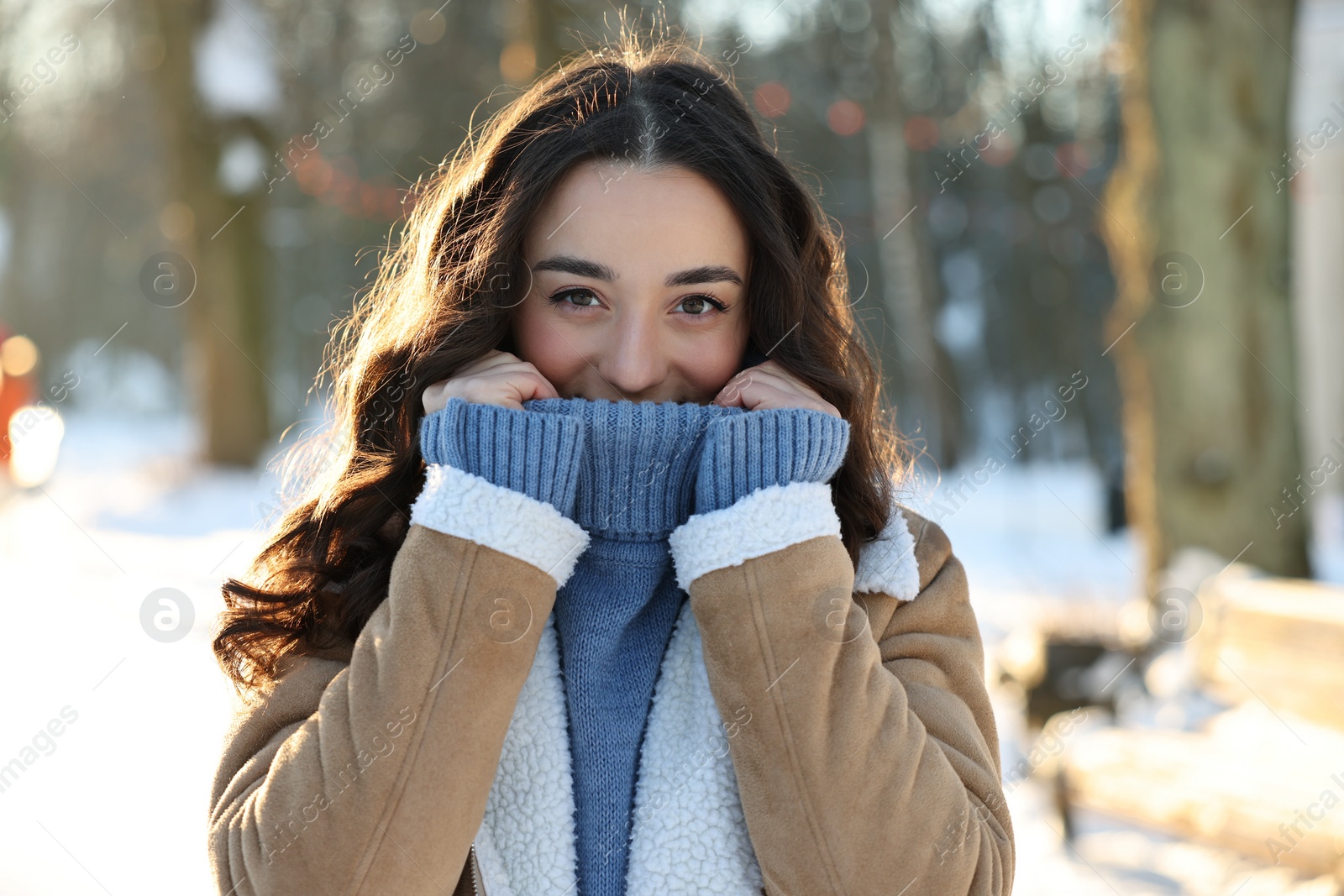 Photo of Portrait of young woman in sunny snowy park