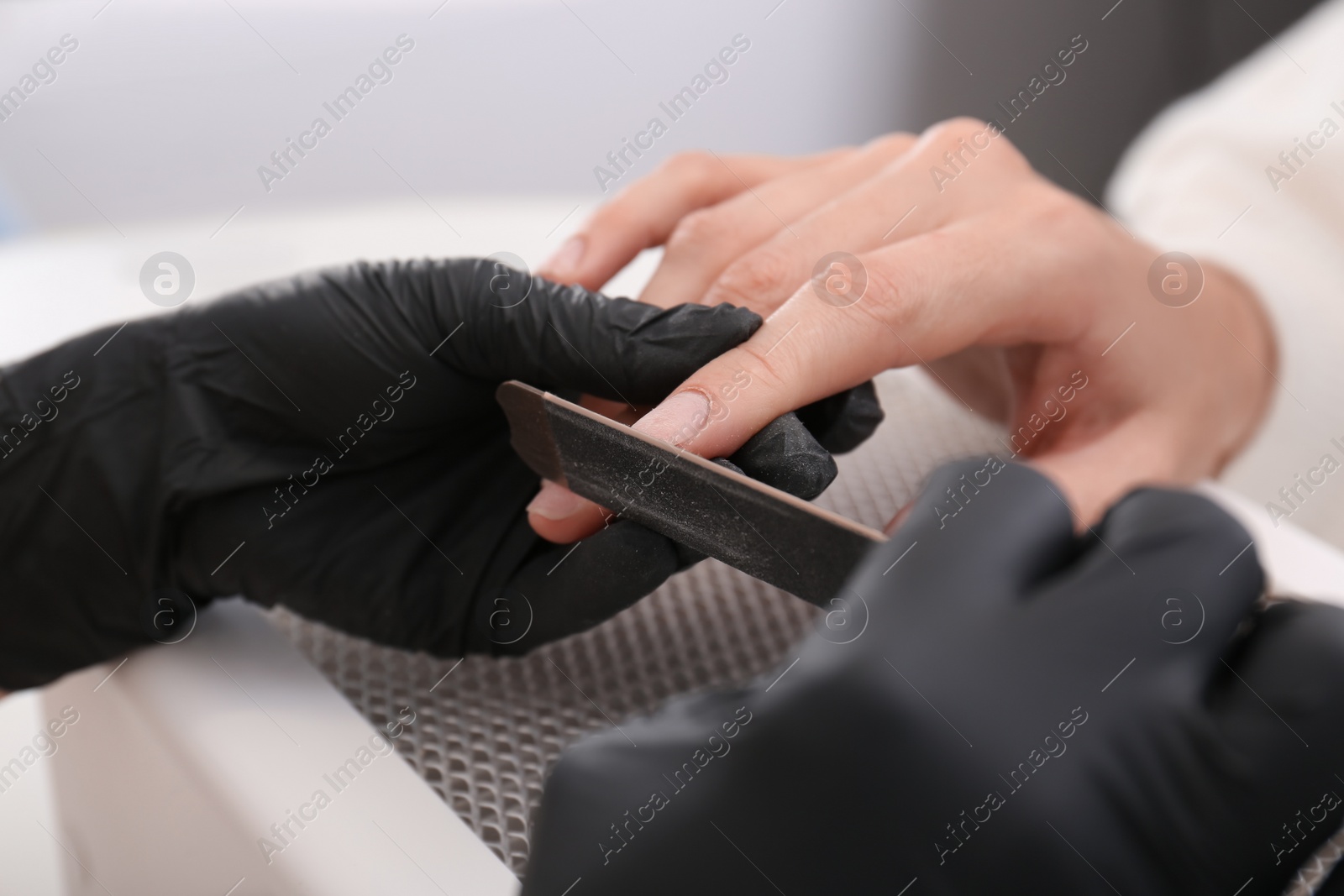 Photo of Professional manicurist working with client, closeup view