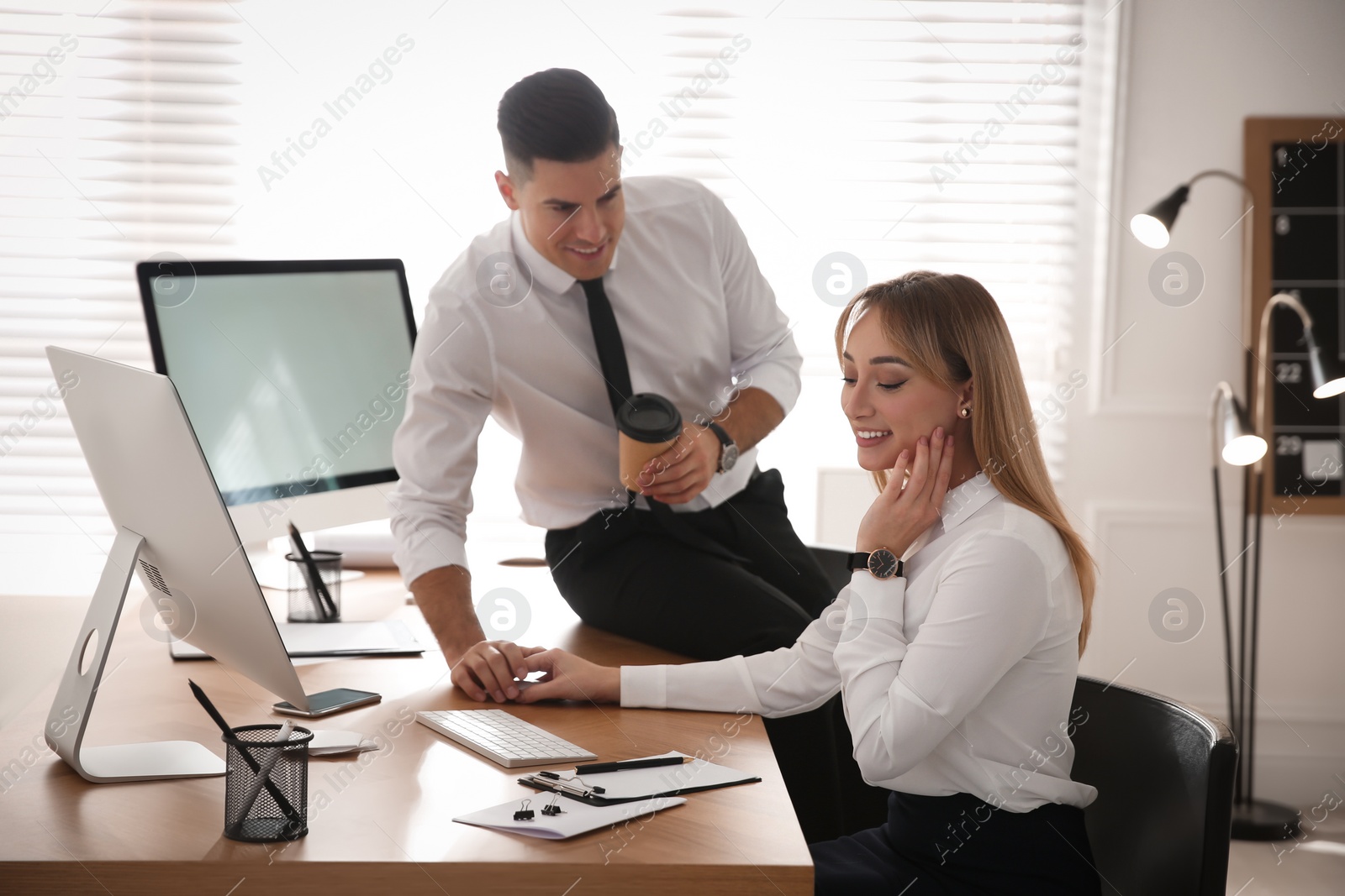 Photo of Man flirting with his colleague during work in office