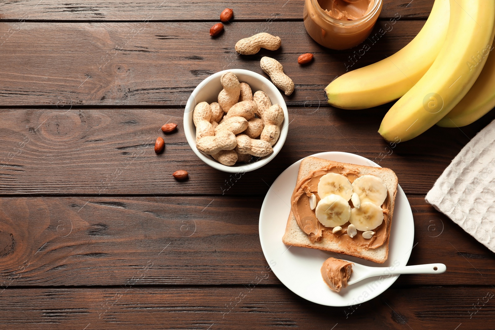 Photo of Flat lay composition with toast bread, peanut butter and bananas on wooden table