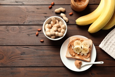 Photo of Flat lay composition with toast bread, peanut butter and bananas on wooden table