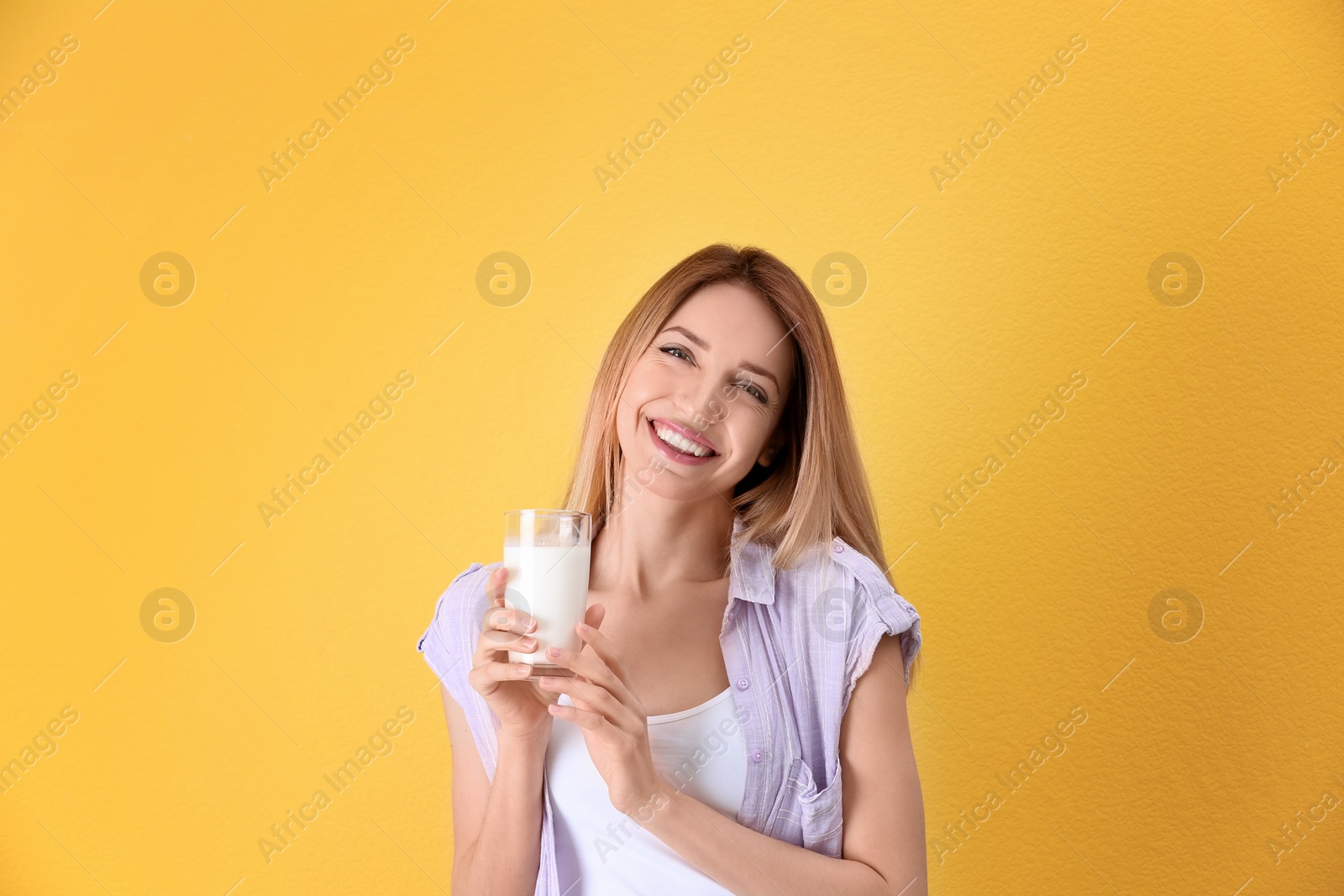 Photo of Beautiful young woman drinking milk on color background