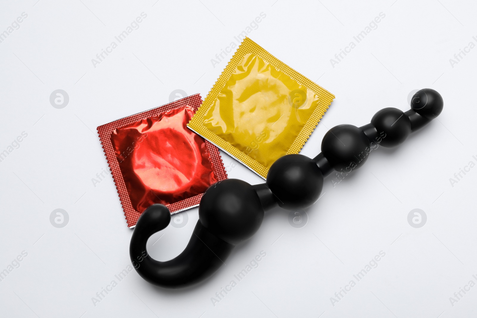 Photo of Anal ball beads and condoms on white background, top view. Sex game
