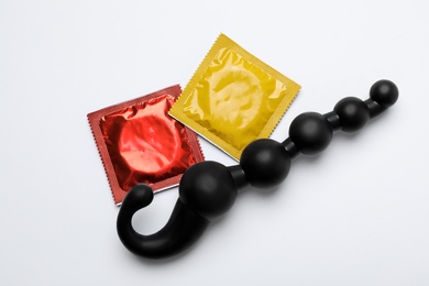 Photo of Anal ball beads and condoms on white background, top view. Sex game