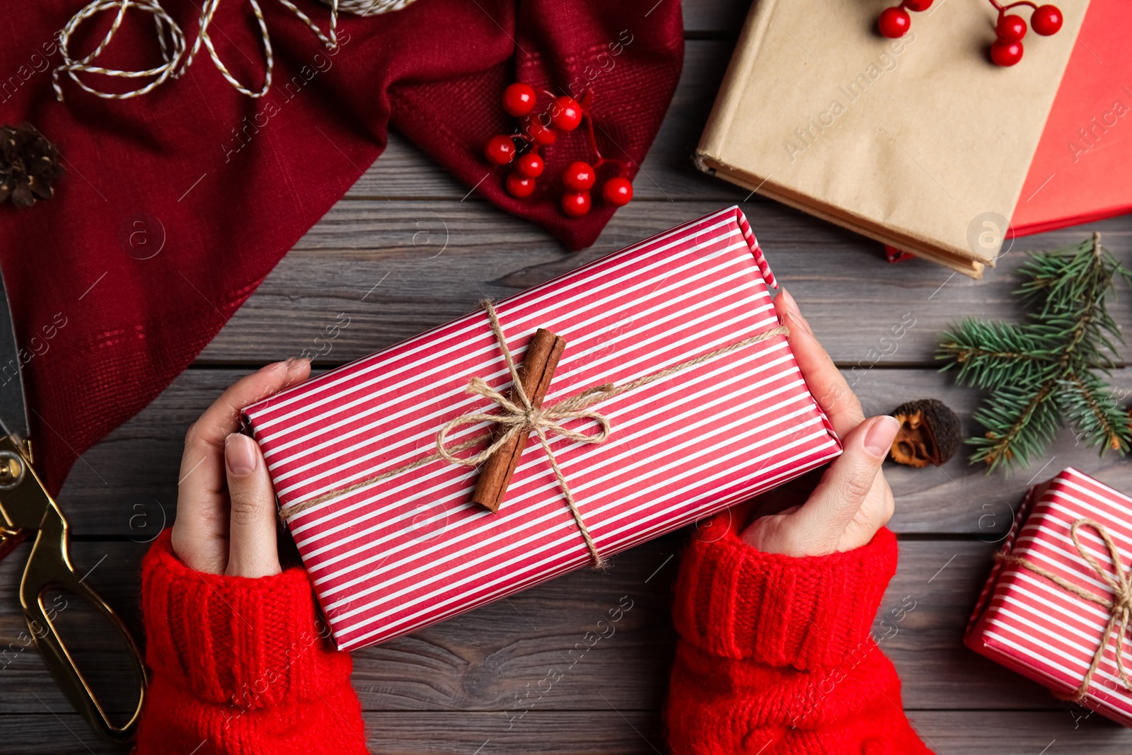 Photo of Woman with gift box at wooden table, top view