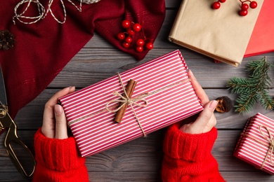 Photo of Woman with gift box at wooden table, top view