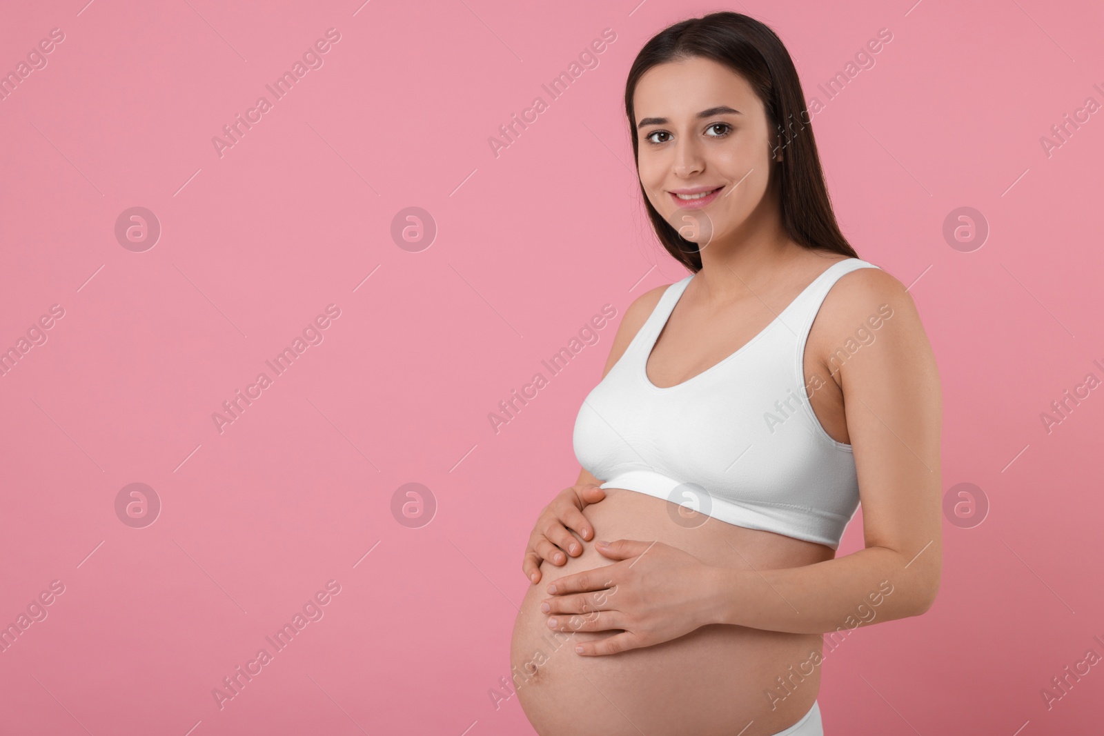 Photo of Beautiful pregnant woman in stylish comfortable underwear on pink background, space for text