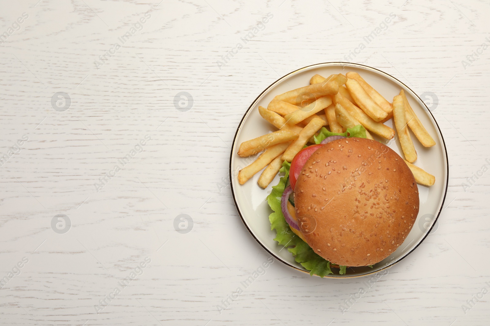 Photo of French fries and tasty burger on white wooden table, top view. Space for text