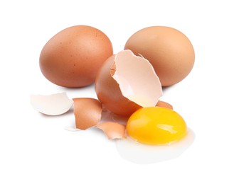 Chicken eggs, pieces of shell and yolk isolated on white