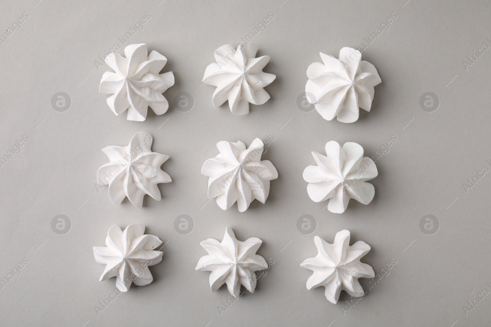 Photo of Tasty meringue cookies on light grey background, flat lay