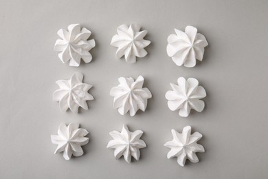 Tasty meringue cookies on light grey background, flat lay