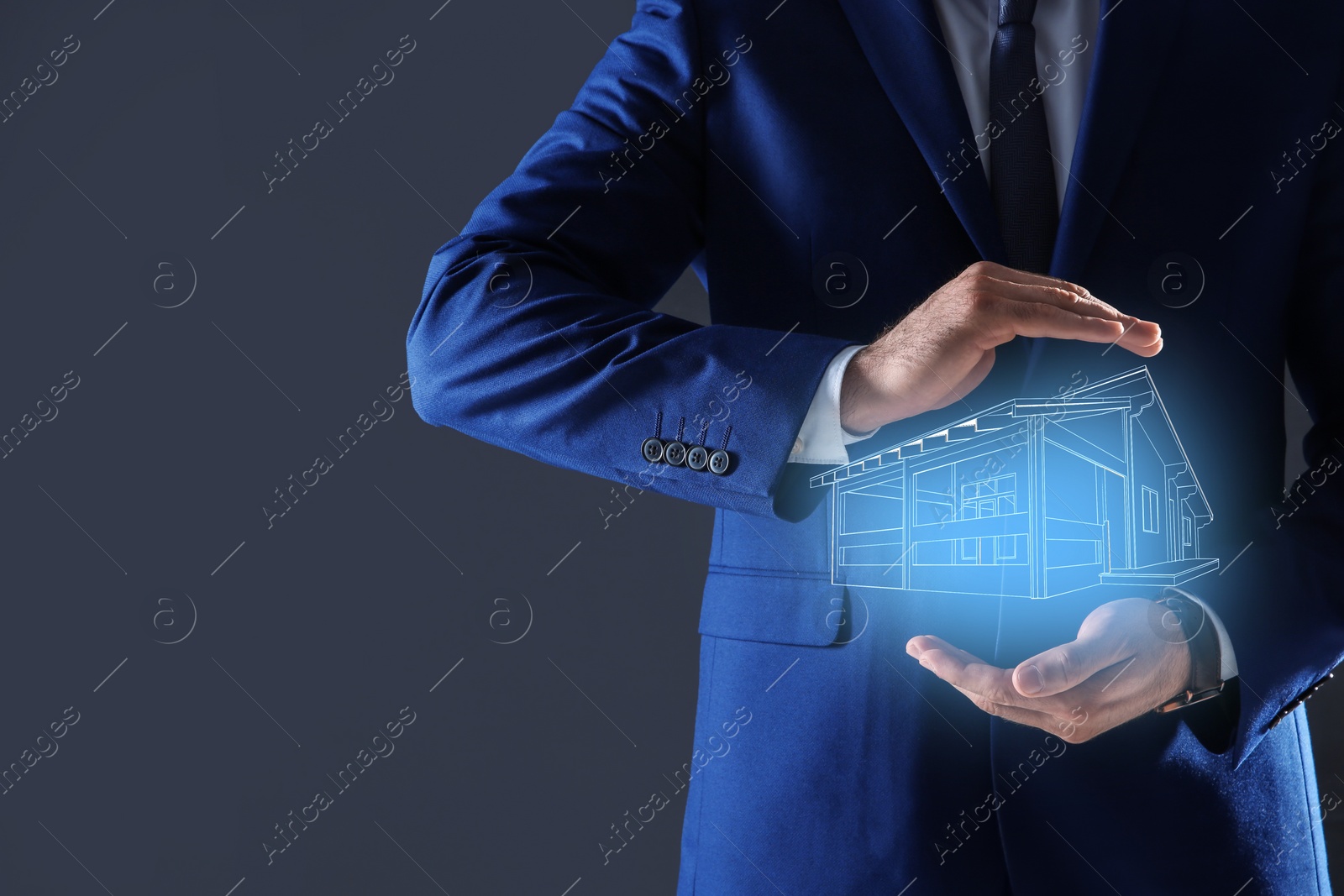 Image of Real estate agent demonstrating house illustration on dark background, closeup