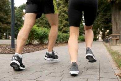 Healthy lifestyle. Couple running in park, closeup