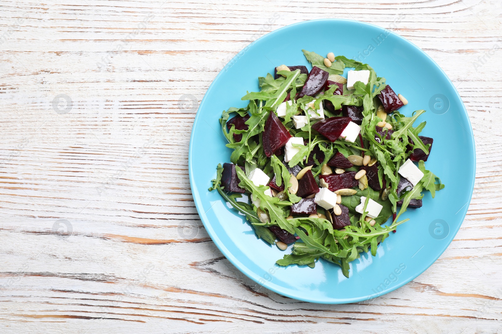 Photo of Fresh delicious beet salad on white wooden table, top view. Space for text