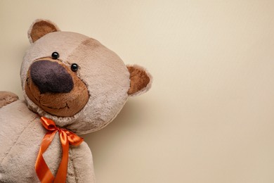 Photo of Cute teddy bear on beige background, top view. Space for text