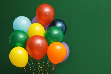 Photo of Bunch of bright balloons on color background, space for text. Celebration time