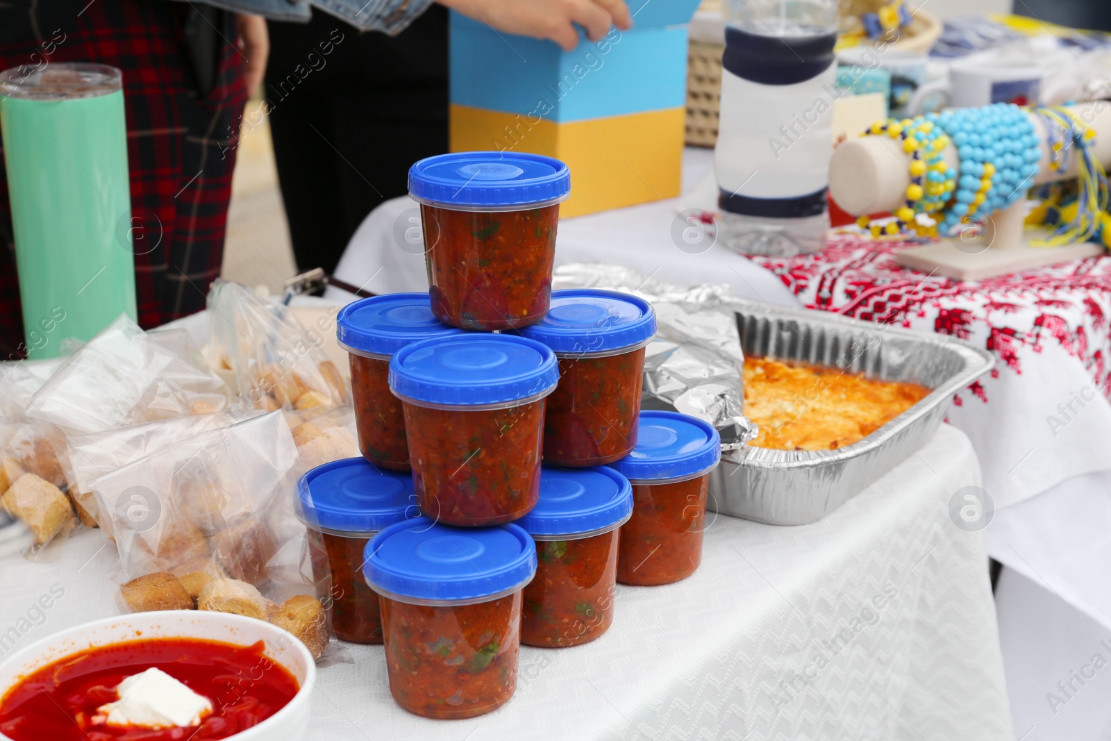 Photo of Volunteer food distribution. Different tasty meals served on table outdoors