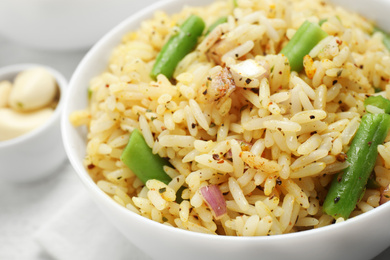 Photo of Tasty rice pilaf with vegetables on table, closeup