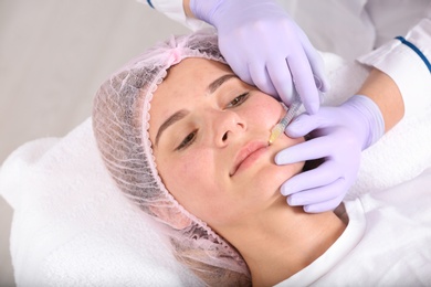 Photo of Woman undergoing face biorevitalization procedure in salon. Cosmetic treatment