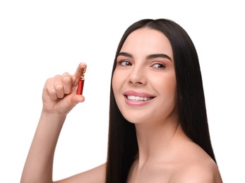 Beautiful young woman holding skincare ampoule on white background