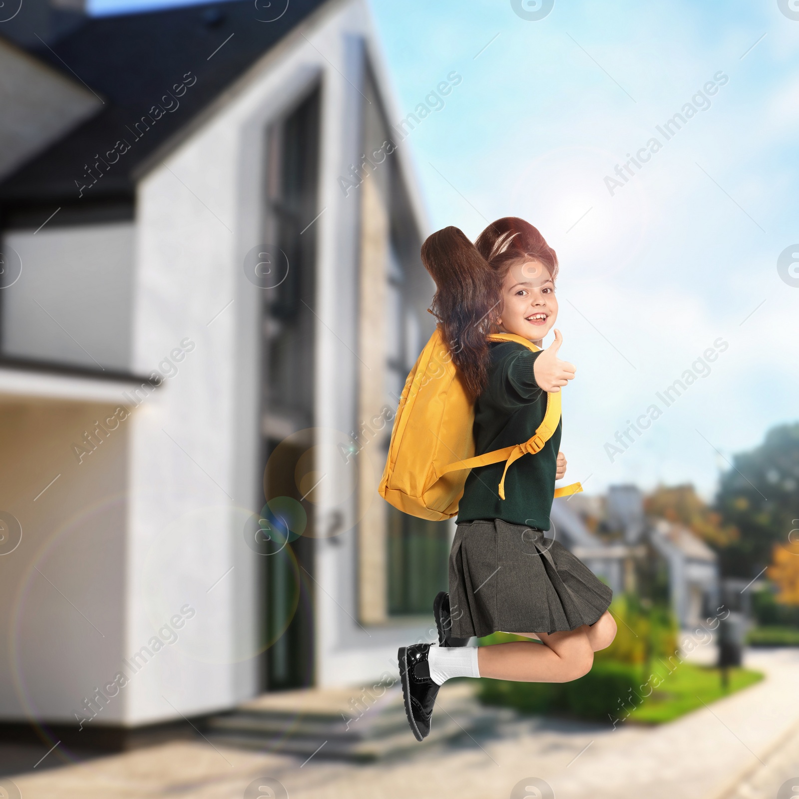 Image of Happy girl jumping near house. School holidays