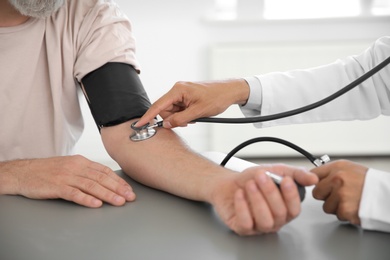 Doctor measuring patient's blood pressure in hospital