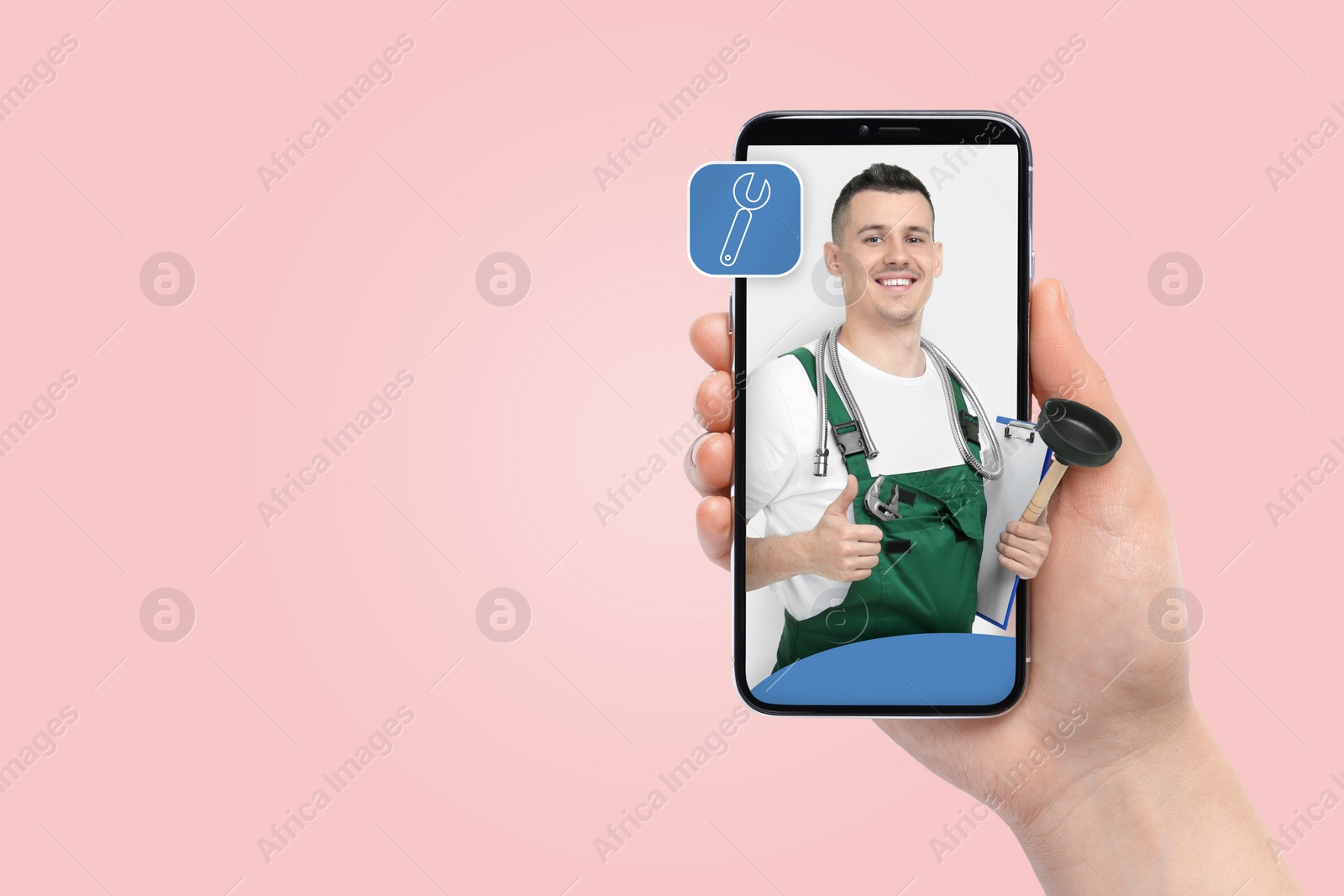 Image of Find plumber. Woman using mobile phone on pink background, closeup. Specialist looking out of gadget