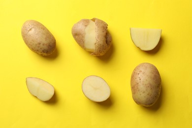 Photo of Fresh raw potatoes on yellow background, flat lay