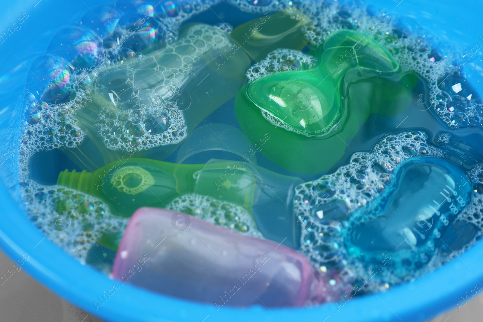 Photo of Light blue basin with baby bottles, closeup