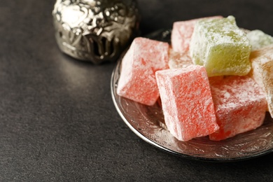 Photo of Turkish delight dessert on dark table, closeup. Space for text