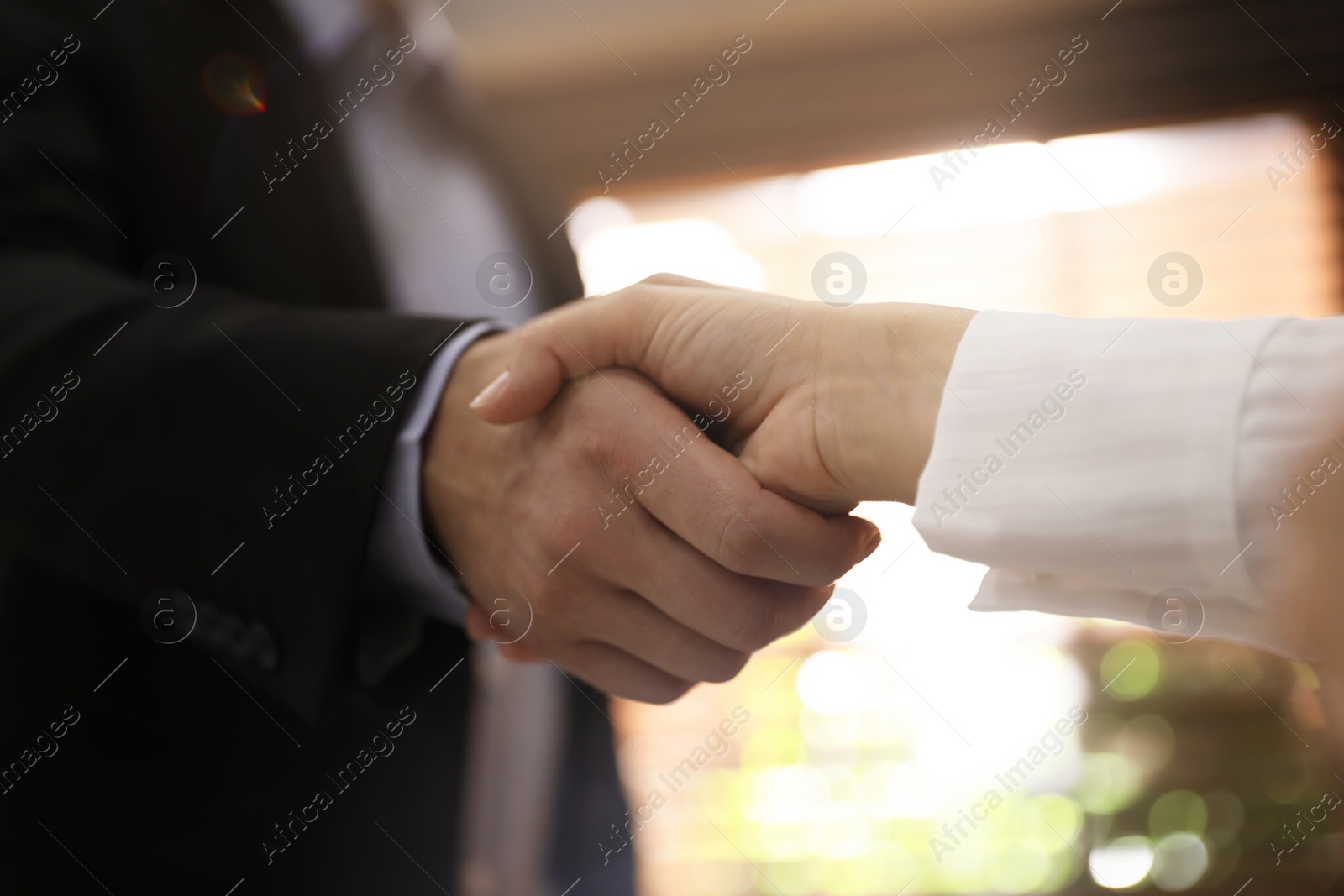 Photo of Business people shaking hands in office, closeup