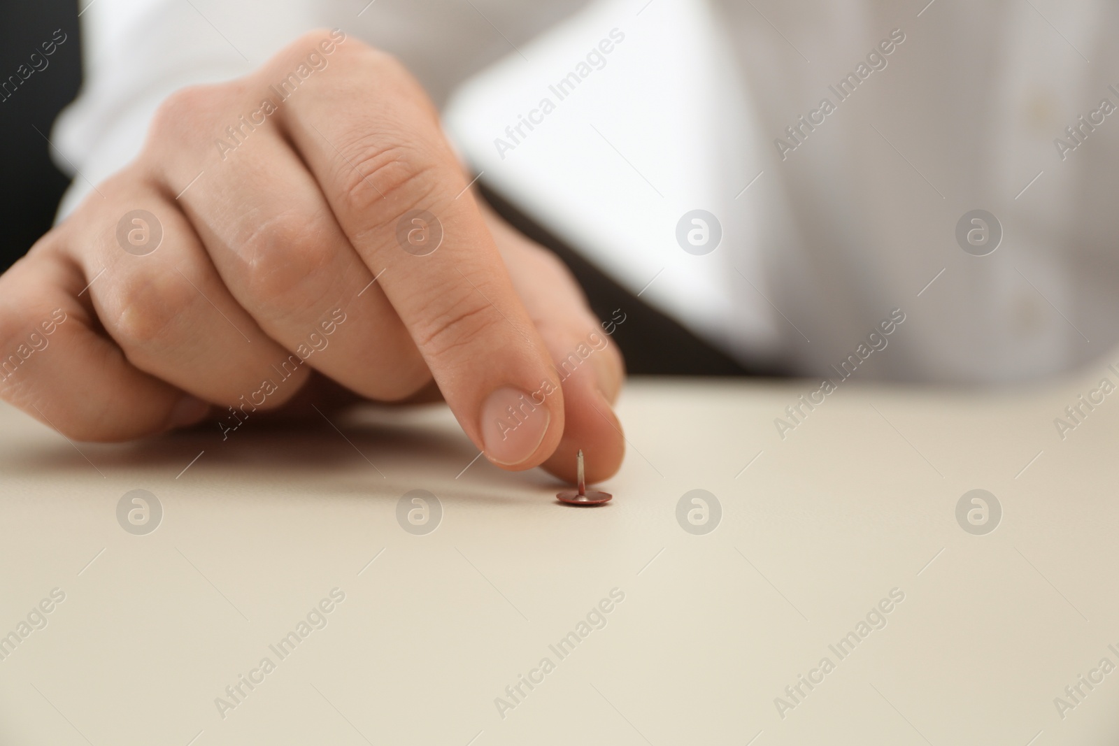 Photo of Man putting pin on chair, closeup. April fool's day