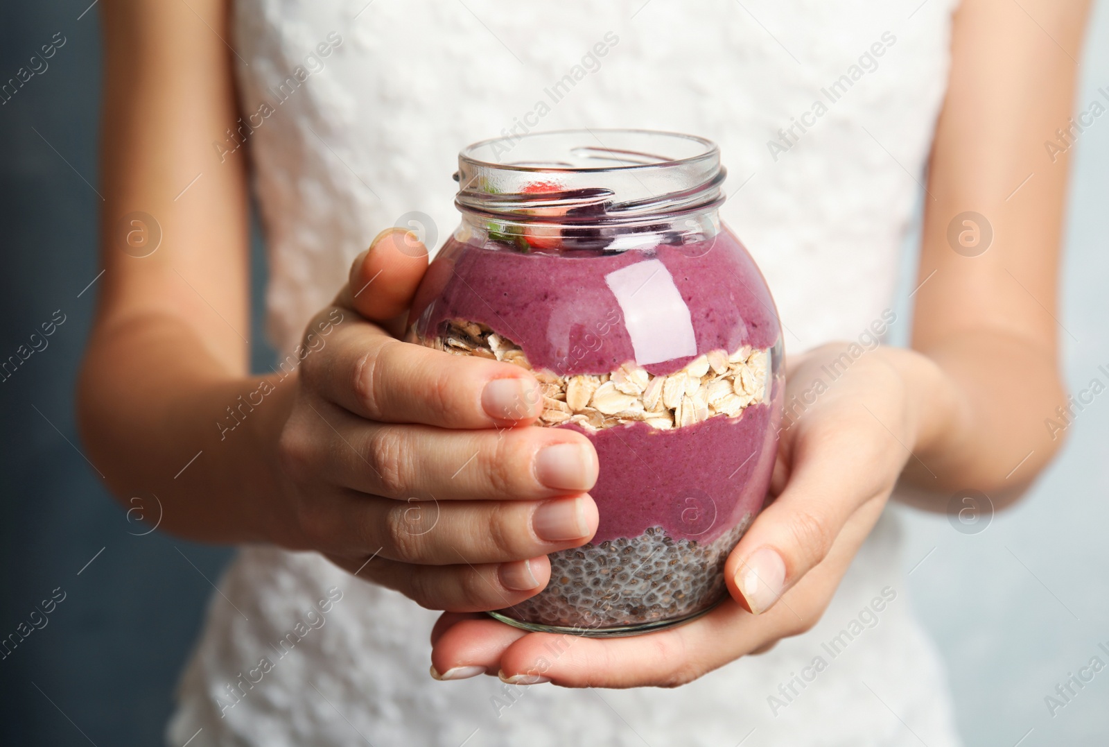 Photo of Woman holding jar with tasty acai smoothie, closeup