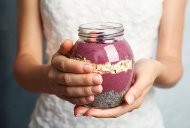 Woman holding jar with tasty acai smoothie, closeup