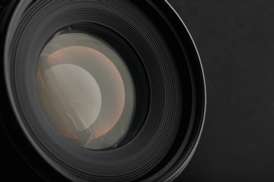 Photo of Modern camera lens on black background, closeup