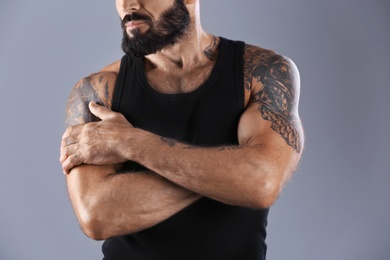 Photo of Tattooed man on grey background, closeup view