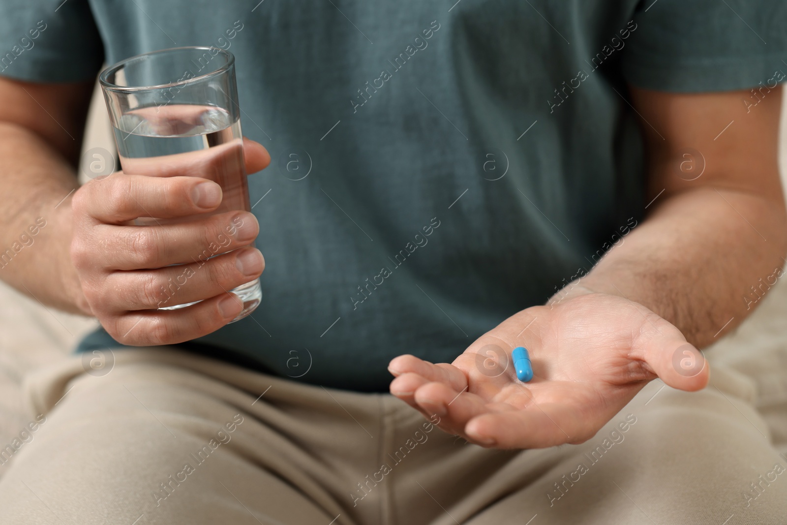 Photo of Man with glass of water and pill, closeup