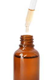 Brown bottle and dropper with essential oil on white background