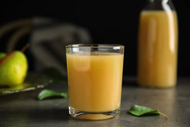 Fresh pear juice in glass on grey table, closeup