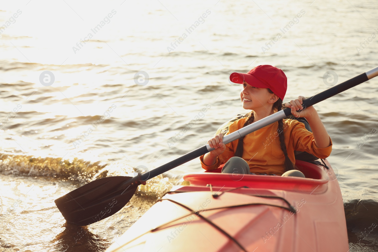 Photo of Happy girl kayaking on river. Summer camp activity