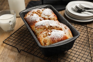 Delicious yeast dough cake in baking pan on wooden table