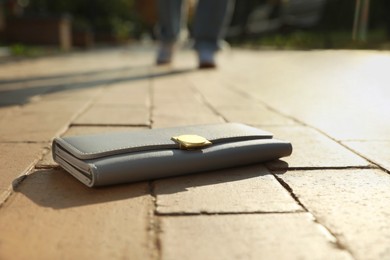 Photo of Woman lost her purse on pavement outdoors, selective focus. Space for text