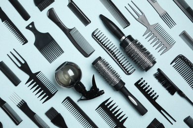 Photo of Flat lay composition with modern hair combs and brushes on light background