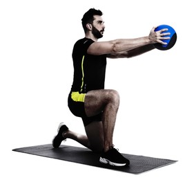 Athletic man doing exercise with medicine ball isolated on white