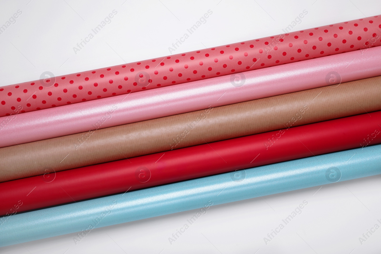 Photo of Rolls of different bright wrapping paper on white background, top view