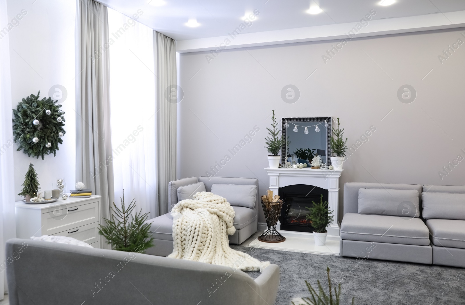 Photo of Stylish living room interior with little fir trees and Christmas decorations