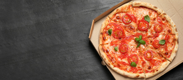 Image of Top view of hot delicious pizza on dark grey table, space for text. Banner design 