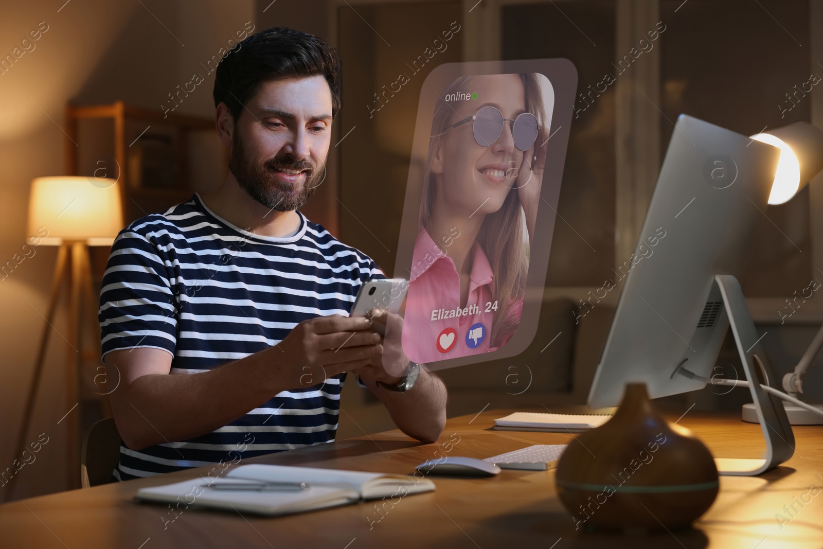 Image of Smiling man looking for partner via dating site indoors. Profile photo of woman, information and icons